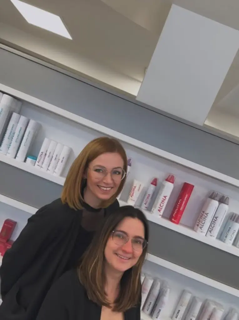 die beiden friseurinnen romy und ines sitzen an der kasse und lachen.