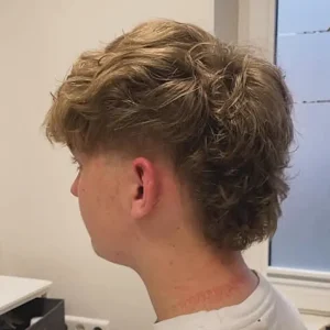 junger blonder herrenkunde mit neuer lockenfrisur. gemacht von Marie